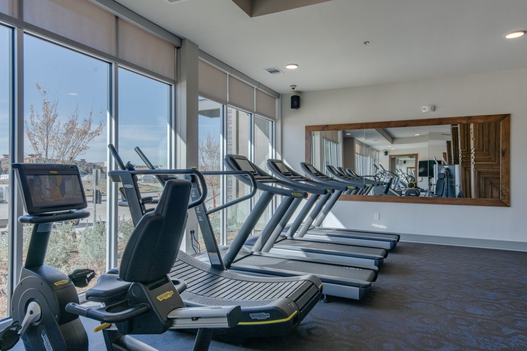 fitness center with treadmills and large mirror
