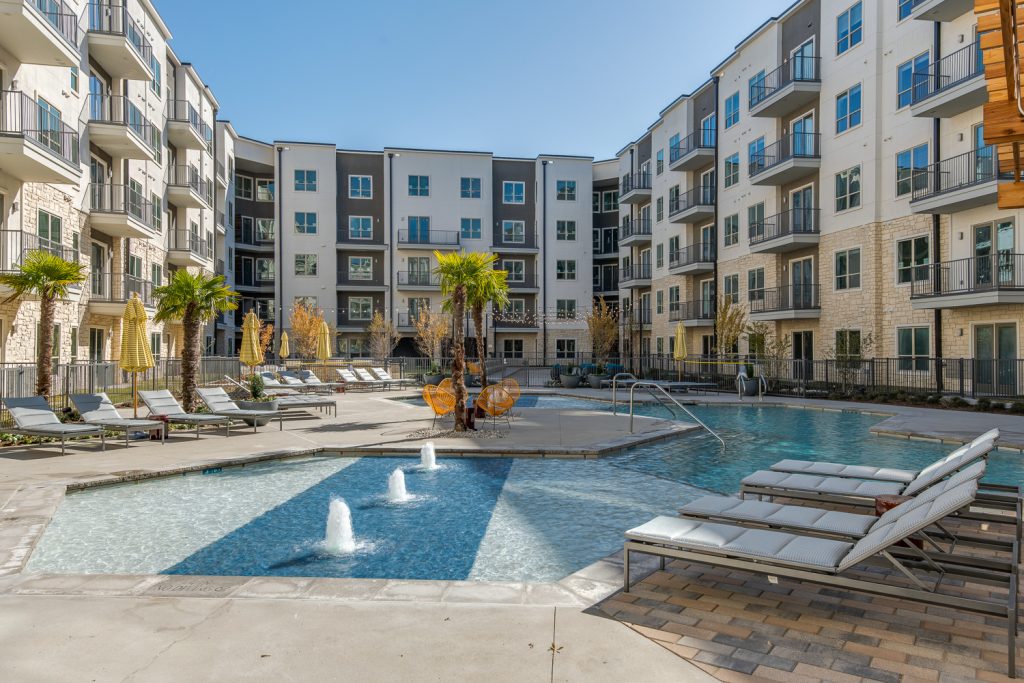 pool with lounge chairs and splash pad