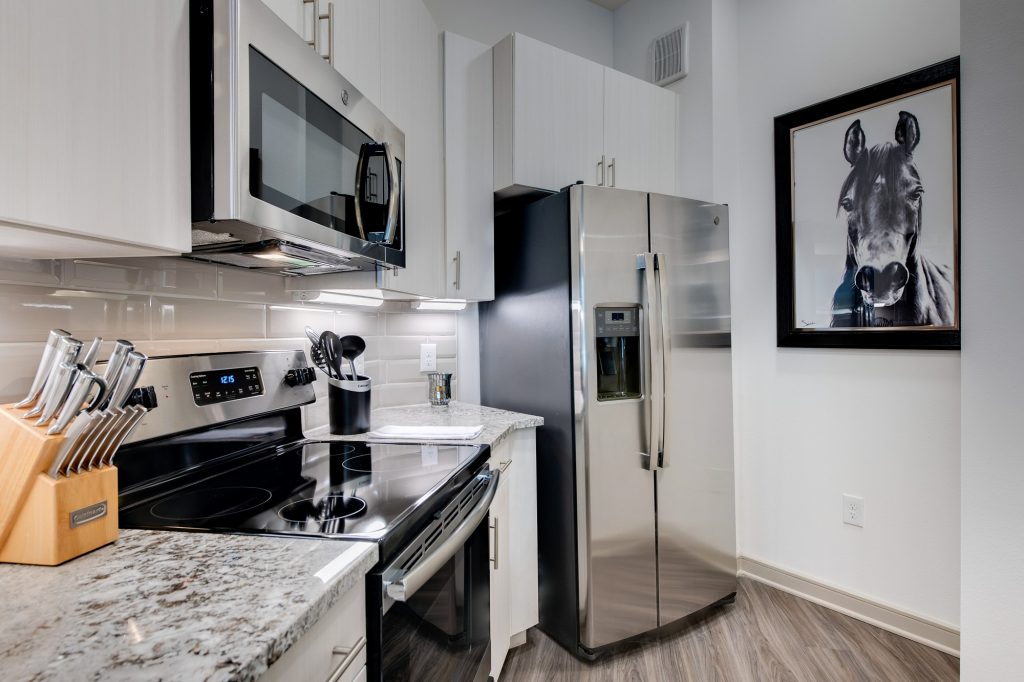 kitchen with granite countertops, steel appliances, and wood flooring