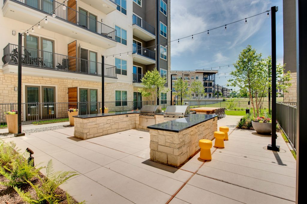 courtyard area with grills and string lights and seating